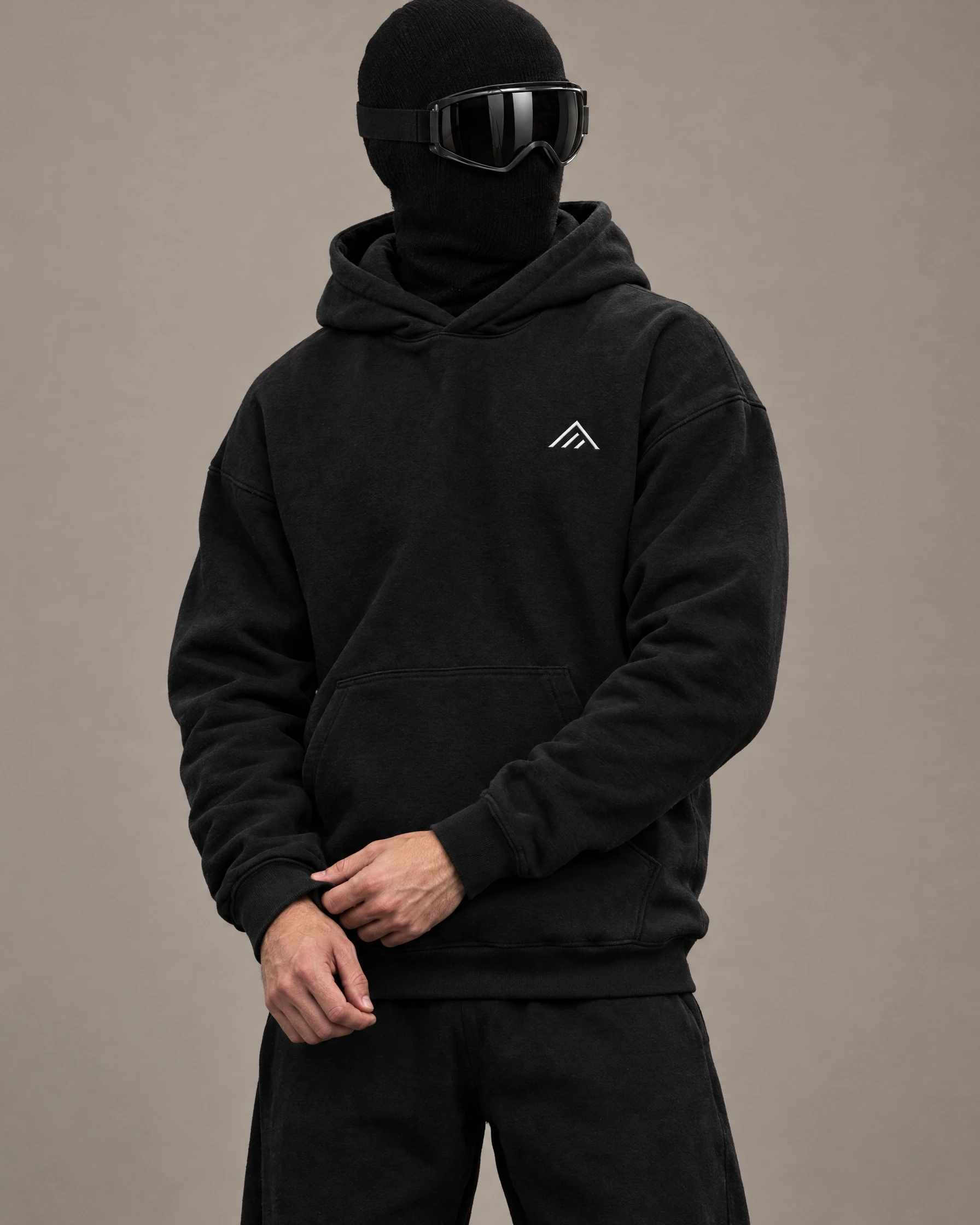 Masked model wearing the black relaxed gym hoodie
